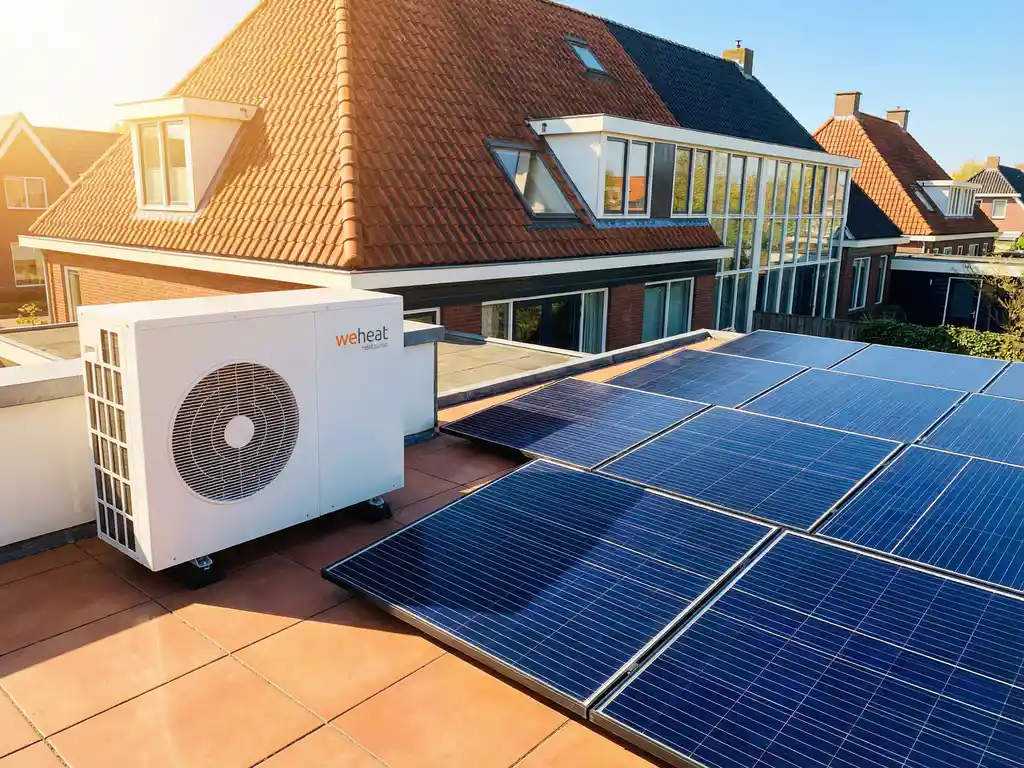 Weheat warmtepomp op zonnig dakterras naast zonnepanelen van moderne Nederlandse woning met terracotta dakpannen